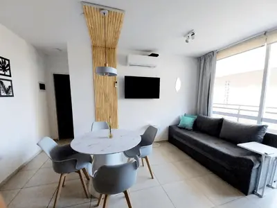 a living room with a black couch and a table at Depto Etoile 2 ubicación confort y amenities in Villa Carlos Paz