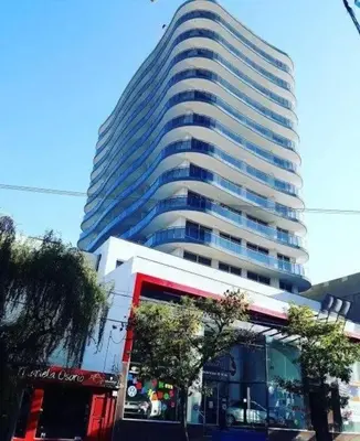 a tall building with a store in front of it at Depto Etoile 2 ubicación confort y amenities in Villa Carlos Paz