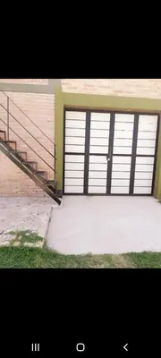 a garage with two doors and a metal staircase at Mis Aromos in Mina Clavero