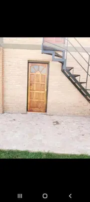 a building with a wooden door and a staircase at Mis Aromos in Mina Clavero