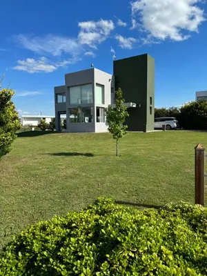 a house in a field with a tree in front of it at Casa Calma Puerto del Aguila in Potrero de Garay