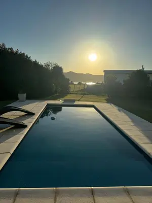 a swimming pool with the sunset in the background at Casa Calma Puerto del Aguila in Potrero de Garay