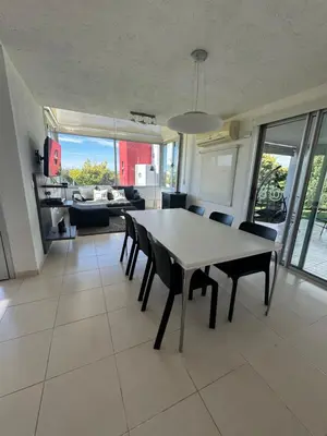 a dining room and living room with a table and chairs at Casa Calma Puerto del Aguila in Potrero de Garay