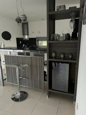 a kitchen with a counter and a bar stool at Casa Calma Puerto del Aguila in Potrero de Garay
