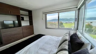 a living room with a couch and a large window at Casa Calma Puerto del Aguila in Potrero de Garay