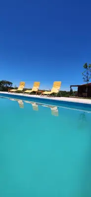 a row of chairs sitting in a swimming pool at Cabañas Potrero de Marquez Paraiso Adult only in Potrero de Garay