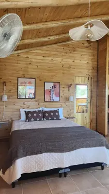 a bedroom with a large bed in a wooden wall at Cabañas Potrero de Marquez Paraiso Adult only in Potrero de Garay