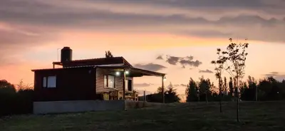 a house on a hill with a sunset in the background at Cabañas Potrero de Marquez Paraiso Adult only in Potrero de Garay