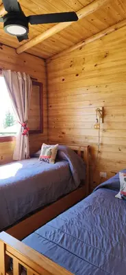 a bedroom with two beds in a log cabin at Cabañas Potrero de Marquez Paraiso Adult only in Potrero de Garay