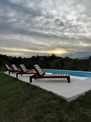 a row of lounge chairs next to a swimming pool at Cabañas Potrero de Marquez Paraiso Adult only in Potrero de Garay