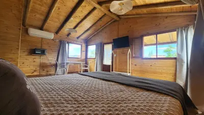 a bedroom with a bed in a room with wooden walls at Cabañas Potrero de Marquez Paraiso Adult only in Potrero de Garay