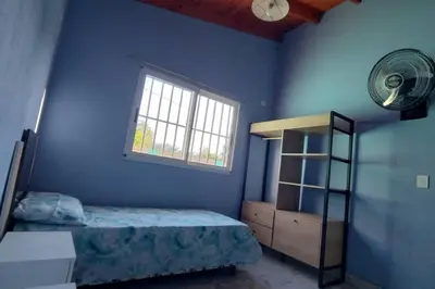 a blue bedroom with a bed and a window at Cabaña dpto en Villa de Merlo in Merlo