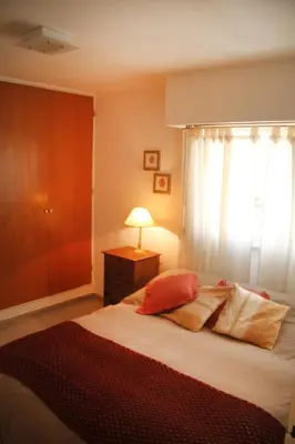 a bedroom with a bed with a lamp and a window at Depto En El Centro - Dean Funes in Cordoba