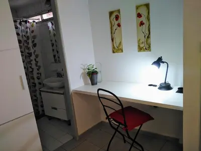 a bathroom with a sink and a red chair at Depto En El Centro - Dean Funes in Cordoba