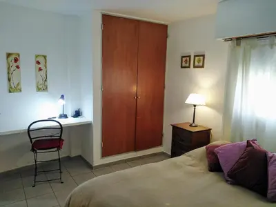 a bedroom with a bed and a chair and a cabinet at Depto En El Centro - Dean Funes in Cordoba