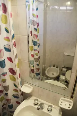 a bathroom with a sink and a toilet and a mirror at Depto En El Centro - Dean Funes in Cordoba