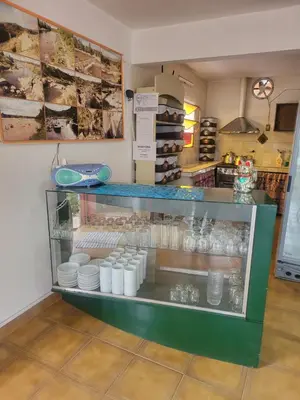 a display case in a kitchen with plates and bowls at Hotel Car Mar in Mina Clavero
