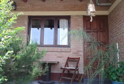a wooden chair sitting in front of a house at Nahian in Mina Clavero