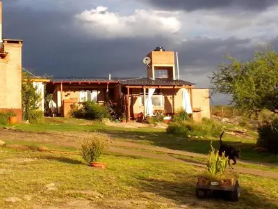 a house with a dog walking in front of it at Nahian in Mina Clavero
