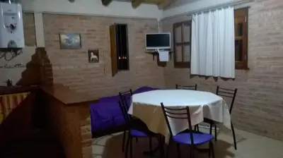a dining room with a table and chairs and a tv at Nahian in Mina Clavero