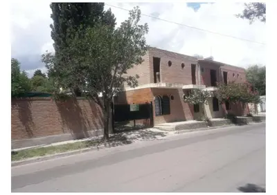 a brick building on the side of a street at Mis helechos in Mina Clavero
