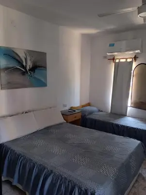 a room with two beds and a painting on the wall at Mis helechos in Mina Clavero