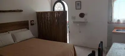 a bedroom with a bed and a bathroom with a sink at Mis helechos in Mina Clavero
