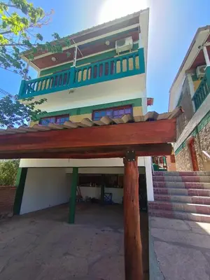 a building with a wooden beam in front of it at Pecas house in Mina Clavero