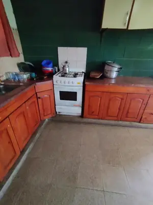 a kitchen with a stove and some wooden cabinets at Pecas house in Mina Clavero