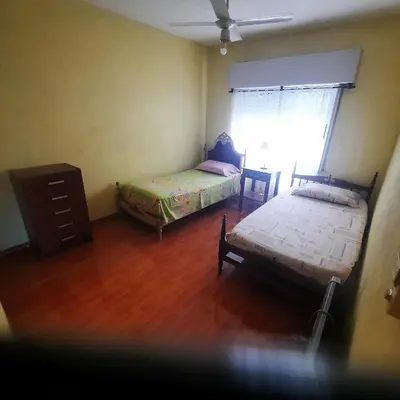 a bedroom with two beds and a dresser and a window at El sueño de papá in Santa María