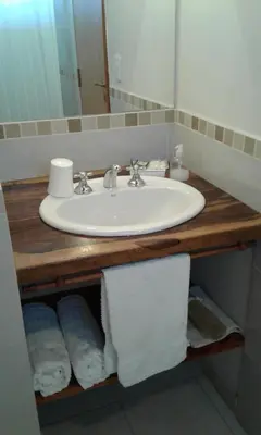 a bathroom sink with towels on a wooden counter at La Soleada in Mina Clavero