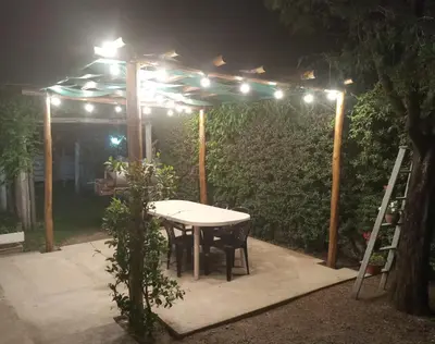 a table and chairs under a pergola at night at La Soleada in Mina Clavero