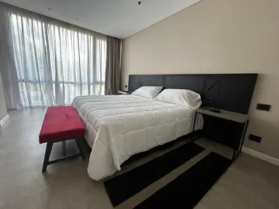 a bedroom with a large bed and a red bench at Graciana Residences-Apart in Trapiche