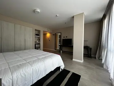 a bedroom with a large white bed and a television at Graciana Residences-Apart in Trapiche