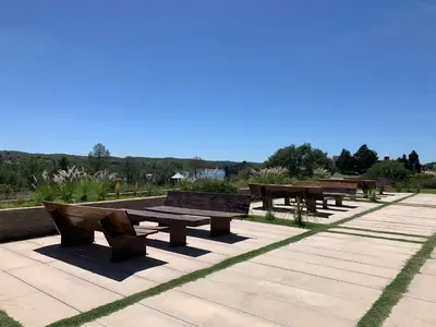 a row of wooden picnic tables in a park at Graciana Residences-Apart in Trapiche