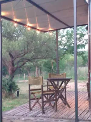 two chairs and a table on a wooden deck at Casa Cosmos, Apart para parejas in Las Rabonas