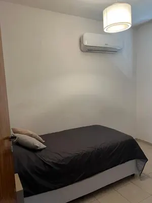 a bed with a black blanket and a light on a wall at Córdoba Shopping - ApartQ 3 in Cordoba