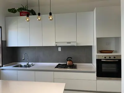 a kitchen with white cabinets and a sink at Córdoba Shopping - ApartQ 3 in Cordoba
