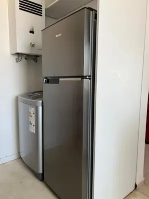 a stainless steel refrigerator in a kitchen next to a trash can at Córdoba Shopping - ApartQ 3 in Cordoba
