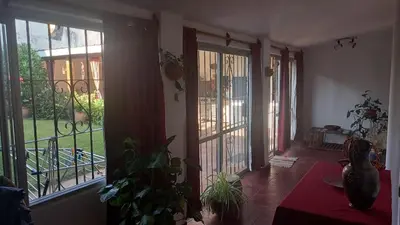 a room with two large windows and a balcony with a plant at CASA AMPLIA Y CONFORTABLE in Cordoba