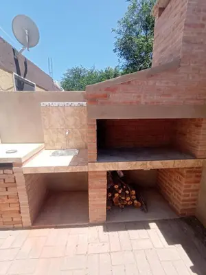 a brick wall with a fire place on a patio at el escondido in Villa Cura Brochero