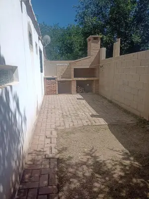 a brick walkway next to a white wall at el escondido in Villa Cura Brochero