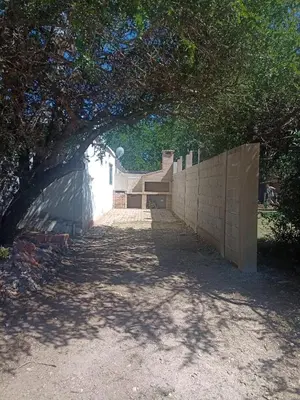 an archway in a wall next to a building at el escondido in Villa Cura Brochero