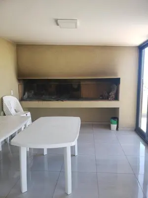 a living room with a white table and a fire place at ALTOS DE ALEM in Alta Gracia