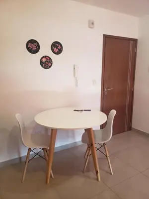 a table and chairs in a room with a clock on the wall at ALTOS DE ALEM in Alta Gracia