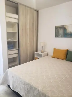 a bedroom with a large white bed and a closet at ALTOS DE ALEM in Alta Gracia