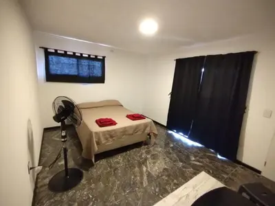 a bedroom with a bed and a fan in it at La Mora in Mina Clavero
