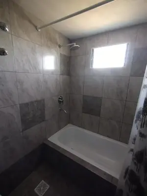 a bathroom with a bath tub and a window at La Mora in Mina Clavero