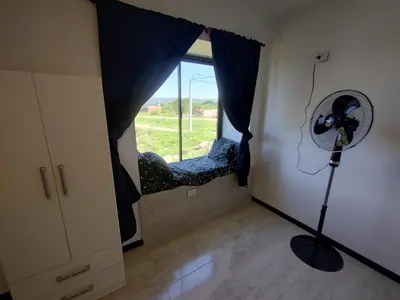 a room with a fan and a window with a chair at La Mora in Mina Clavero