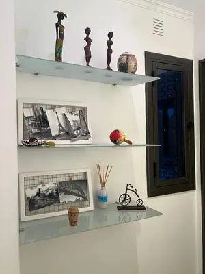 a shelf on a wall with pictures on it at Palacio 210 - Plaza España - Nueva Córdoba - 2 dormitorios in Cordoba